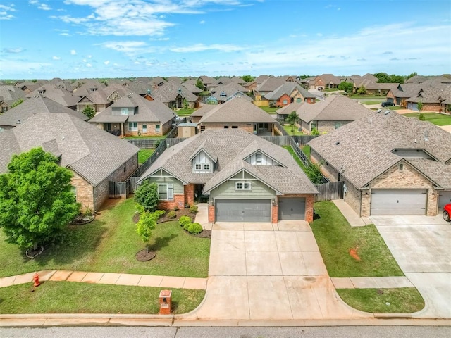 view of front facade with a residential view, fence, driveway, and brick siding