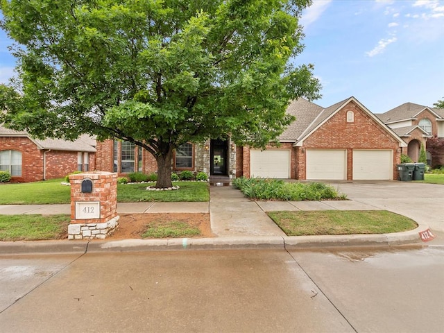 view of front of house with brick siding, an attached garage, concrete driveway, a front yard, and a shingled roof