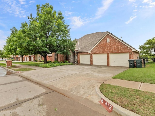 view of front of property featuring brick siding, a front lawn, driveway, and an attached garage