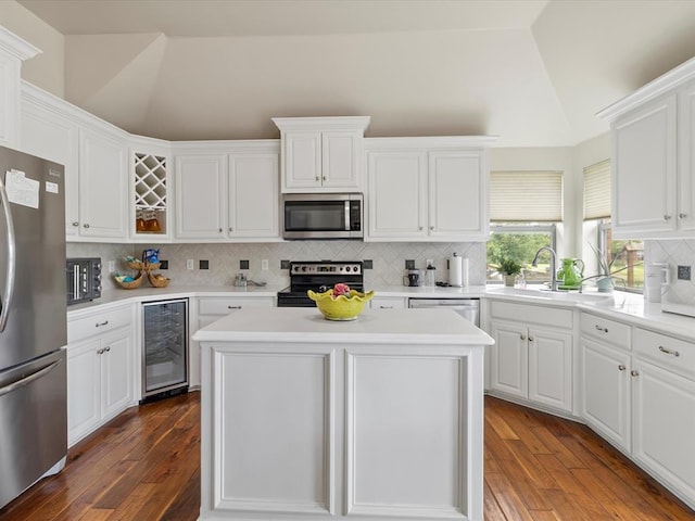 kitchen with appliances with stainless steel finishes, beverage cooler, tasteful backsplash, dark wood-style floors, and high vaulted ceiling