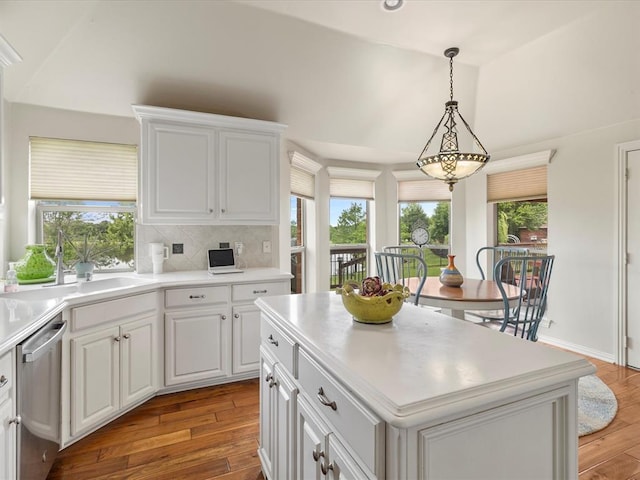 kitchen with dishwasher, a sink, light wood-style flooring, and a kitchen island