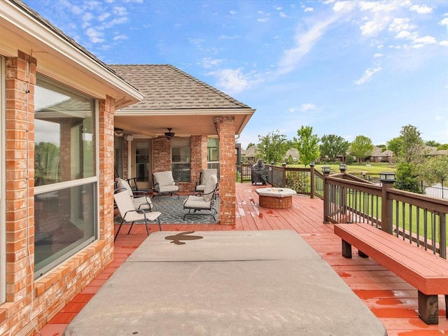 deck with a ceiling fan and a fire pit