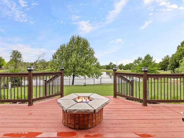 wooden terrace with an outdoor fire pit and a water view