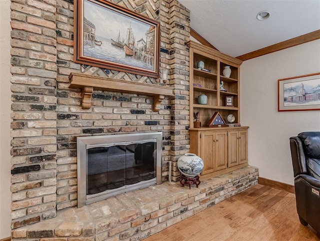 sitting room with baseboards, light wood-style floors, a brick fireplace, and lofted ceiling