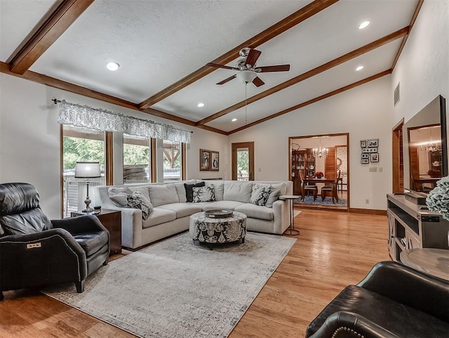 living area featuring light wood-style floors, lofted ceiling with beams, ceiling fan with notable chandelier, and visible vents