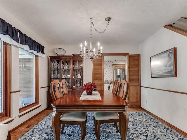 dining area featuring baseboards and a chandelier