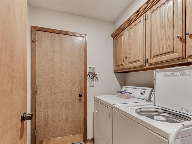 washroom featuring cabinet space and washer and clothes dryer