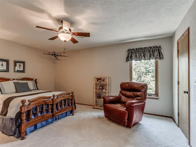 bedroom featuring baseboards, a ceiling fan, a textured ceiling, and light carpet