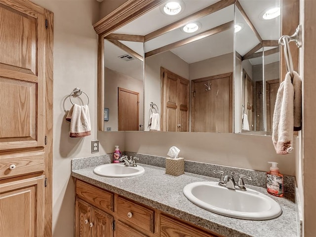 full bathroom with double vanity, visible vents, and a sink
