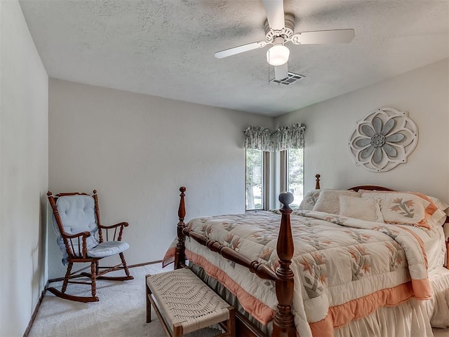 bedroom with ceiling fan, light colored carpet, a textured ceiling, baseboards, and visible vents