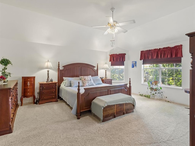 carpeted bedroom with ceiling fan and vaulted ceiling