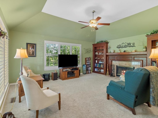 carpeted living room with a premium fireplace, ceiling fan, vaulted ceiling, and visible vents