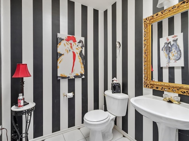 bathroom featuring baseboards, toilet, and wallpapered walls