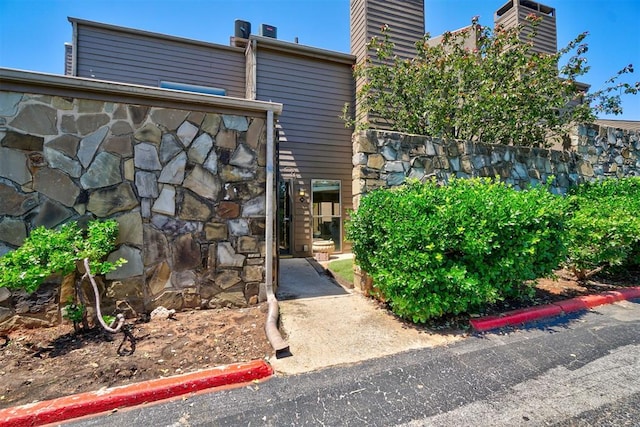 6000 N Pennsylvania Ave Unit 59, Oklahoma City, OK 73112 - exterior space featuring a chimney and stone siding
