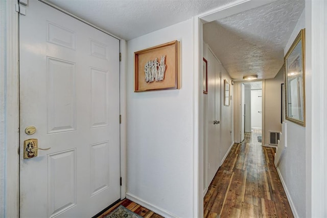 6000 N Pennsylvania Ave Unit 59, Oklahoma City, OK 73112 - hallway featuring baseboards, a textured ceiling, dark wood-style floors, and visible vents