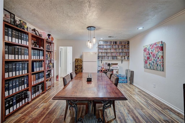 6000 N Pennsylvania Ave Unit 59, Oklahoma City, OK 73112 - dining space featuring baseboards, a textured ceiling, crown molding, and wood finished floors