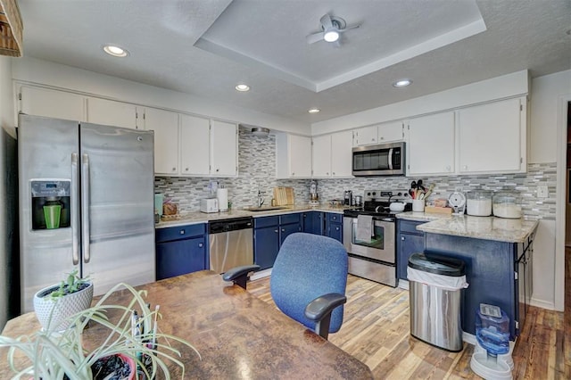 6000 N Pennsylvania Ave Unit 59, Oklahoma City, OK 73112 - kitchen with white cabinets, stainless steel appliances, a raised ceiling, and blue cabinets