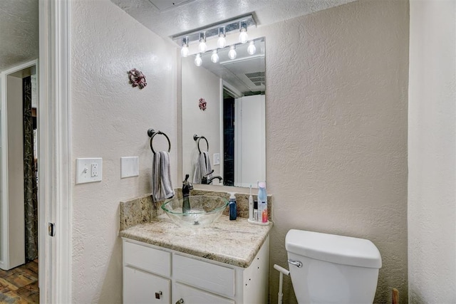 6000 N Pennsylvania Ave Unit 59, Oklahoma City, OK 73112 - bathroom featuring toilet, a textured wall, and vanity