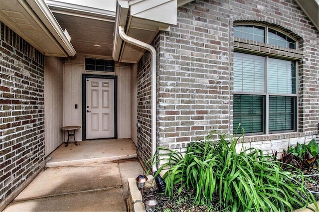 view of exterior entry with brick siding