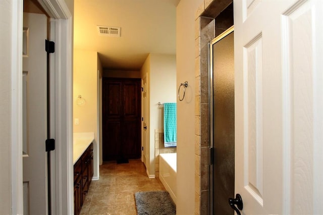 full bath with vanity, a shower stall, and a garden tub