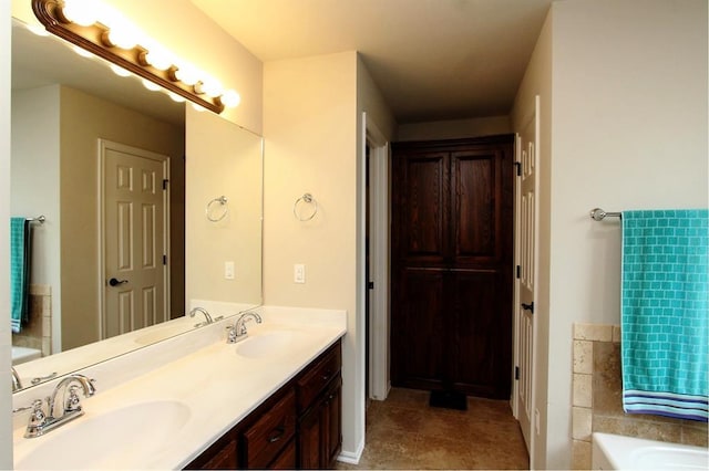 full bath featuring a bath, double vanity, and tile patterned floors
