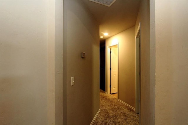 corridor with baseboards and carpet