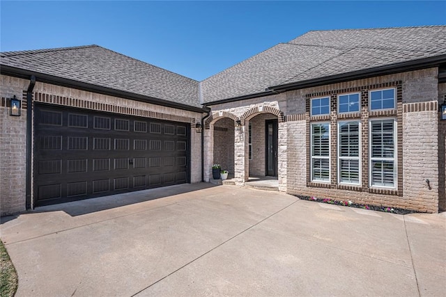 8521 NW 124th St, Oklahoma City, OK 73142 - french provincial home with a shingled roof, concrete driveway, a garage, and brick siding