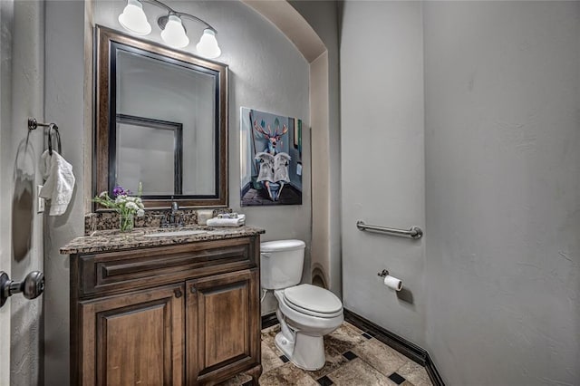 8521 NW 124th St, Oklahoma City, OK 73142 - bathroom featuring toilet, stone tile floors, vanity, and baseboards
