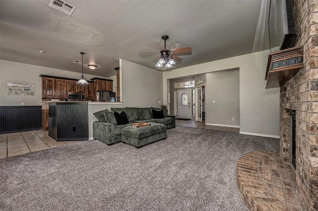 living room featuring visible vents, ceiling fan, light tile patterned floors, and light carpet