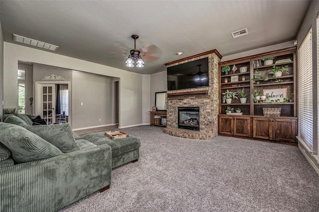 living room featuring visible vents, ceiling fan, carpet floors, and a fireplace