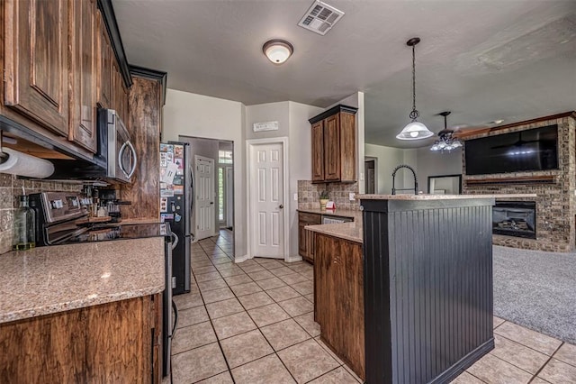 kitchen featuring appliances with stainless steel finishes, open floor plan, decorative backsplash, light tile patterned floors, and visible vents
