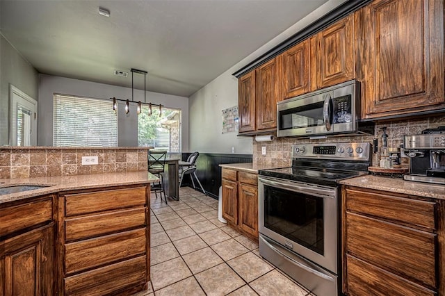 kitchen featuring light tile patterned floors, tasteful backsplash, stainless steel appliances, and visible vents