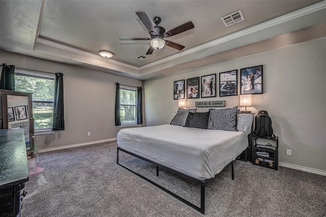bedroom with visible vents, ornamental molding, carpet floors, multiple windows, and a tray ceiling