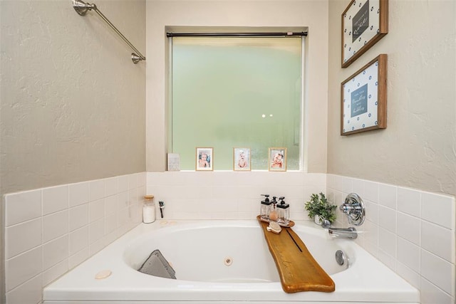 full bathroom with a tub with jets