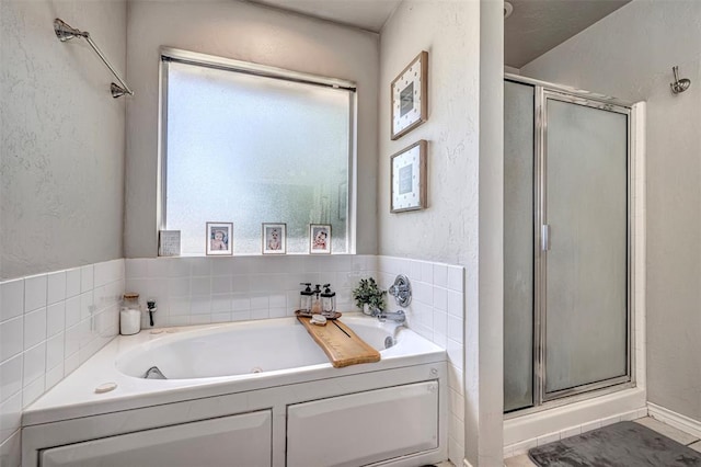 bathroom with a bath, a healthy amount of sunlight, and a shower stall