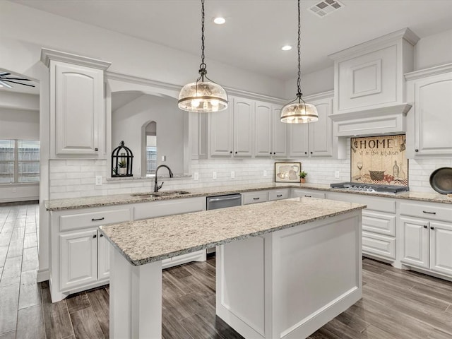 kitchen featuring a sink, stainless steel appliances, a healthy amount of sunlight, a kitchen island, and visible vents