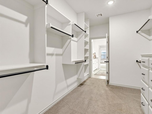 walk in closet with light colored carpet and visible vents