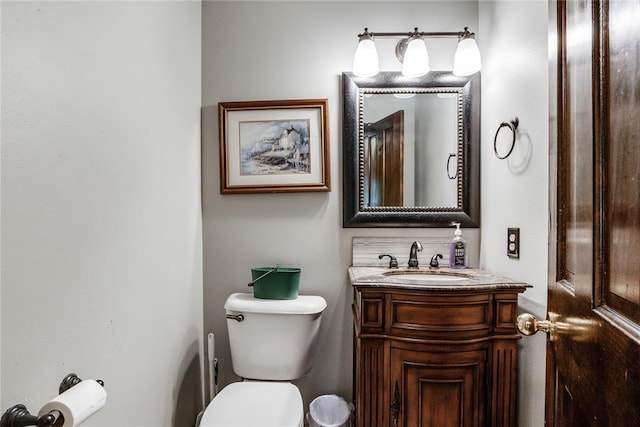 half bath featuring vanity and toilet
