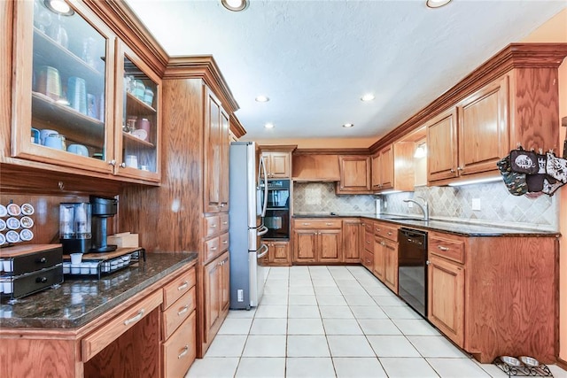 kitchen with backsplash, light tile patterned floors, black appliances, dark stone counters, and recessed lighting