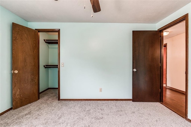 unfurnished bedroom featuring carpet floors, baseboards, a spacious closet, and a closet