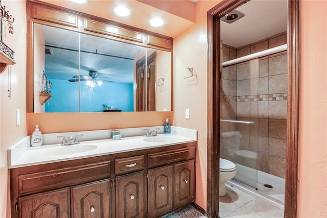 full bath featuring a sink, a shower stall, a ceiling fan, and toilet