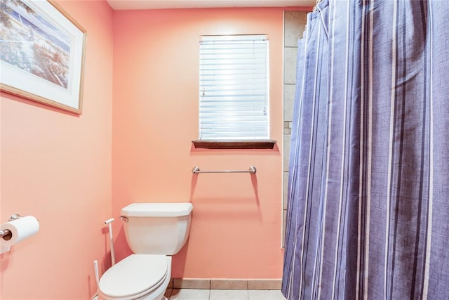 bathroom featuring tile patterned flooring, baseboards, a shower with shower curtain, and toilet