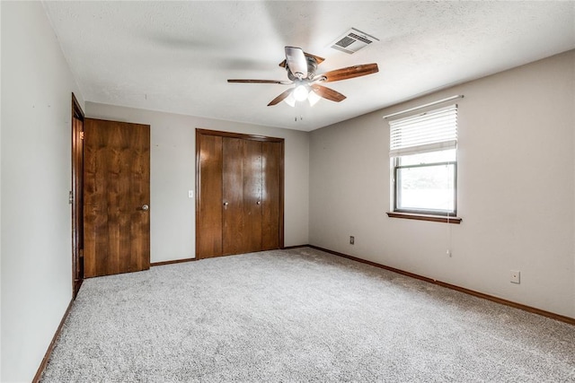 unfurnished bedroom featuring baseboards, visible vents, carpet, and a closet