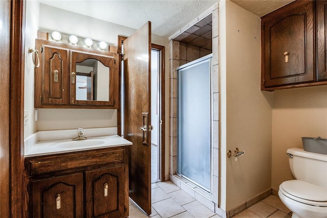 full bath with a textured ceiling, tile patterned flooring, a shower stall, vanity, and toilet