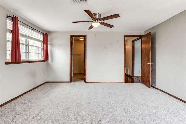 unfurnished bedroom with a ceiling fan, baseboards, visible vents, and carpet