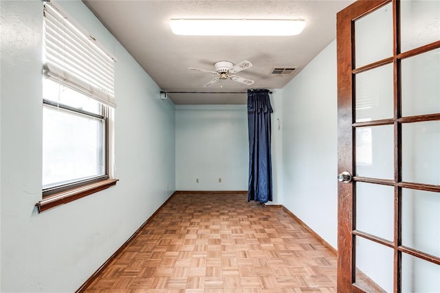 spare room featuring visible vents, baseboards, and ceiling fan