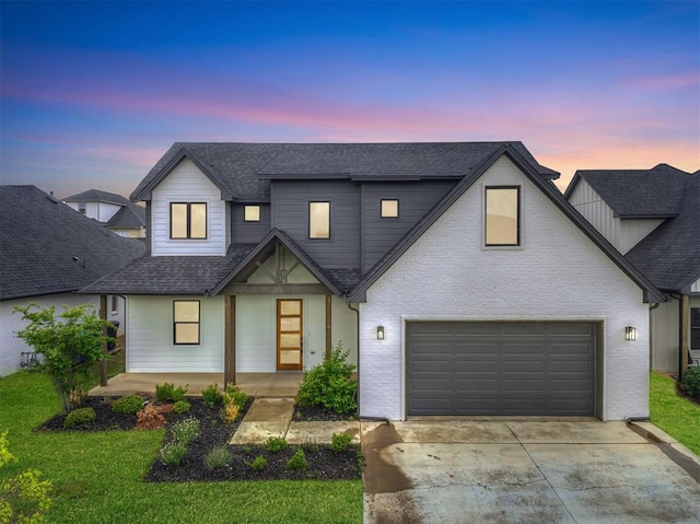 modern farmhouse style home featuring roof with shingles, a front lawn, a garage, a porch, and driveway