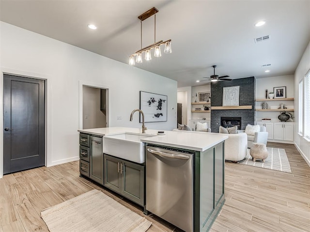 kitchen with a ceiling fan, visible vents, stainless steel dishwasher, a fireplace, and light countertops