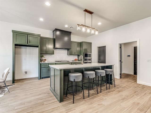kitchen with light countertops, appliances with stainless steel finishes, custom exhaust hood, and green cabinets