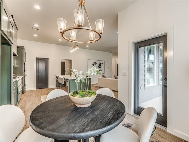 dining area featuring visible vents, recessed lighting, light wood-style flooring, and a notable chandelier